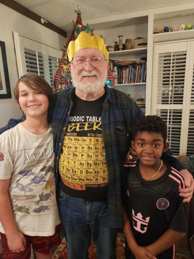 John standing between two of his grandsons, an arm around each